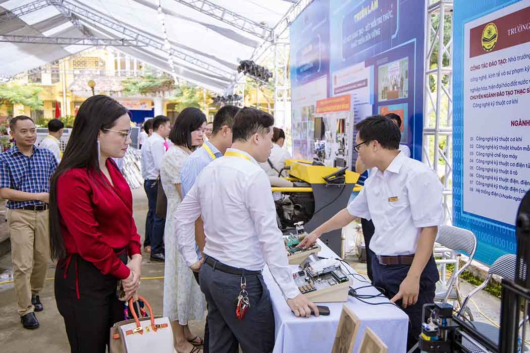 Cán bộ, giảng viên của Trường đang giới thiệu, giải đáp thắc mắc về một sản phẩm công nghệ cho các đại biểu và khách tham quan tại gian hàng