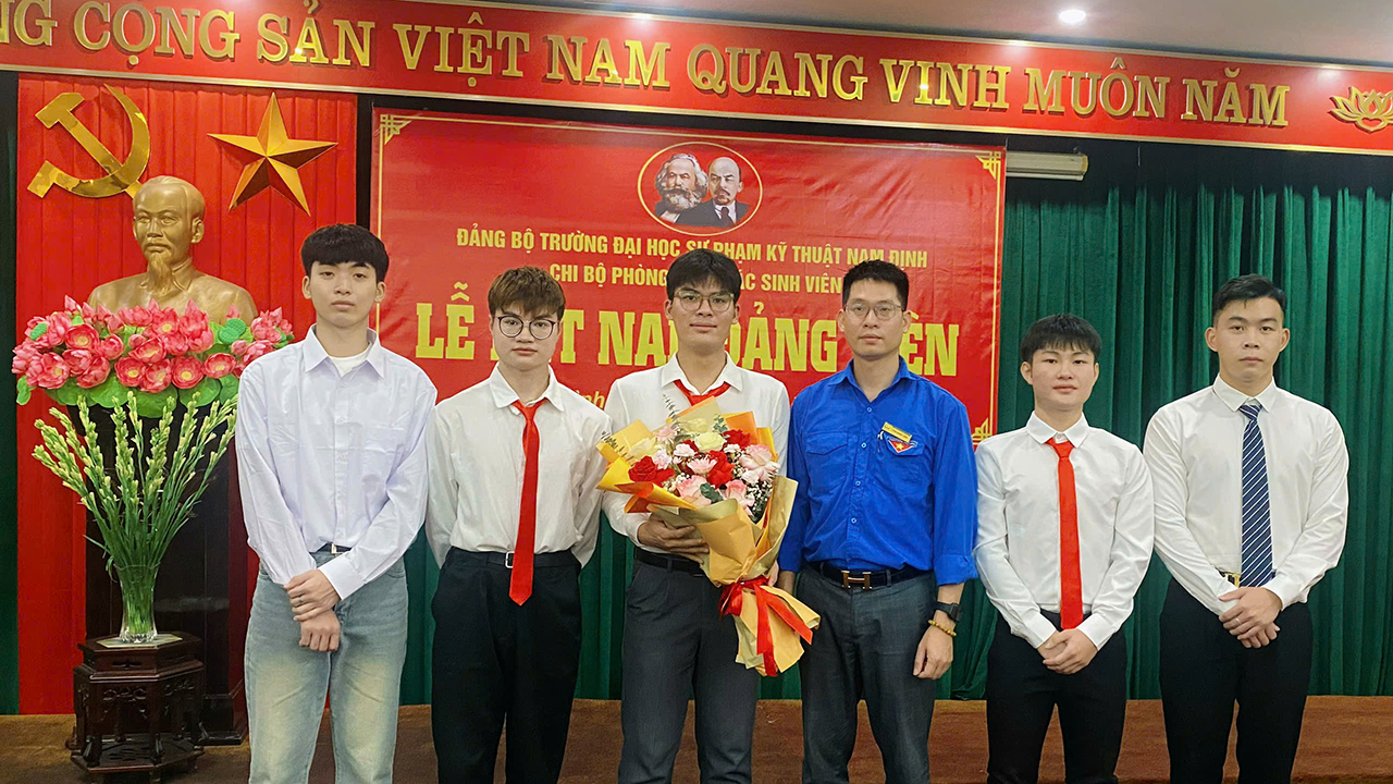 Đồng chí Trần Quang Thịnh - Bí thư Đoàn thanh niên Nhà trường tặng hoa chúc mừng các Đảng viên mới